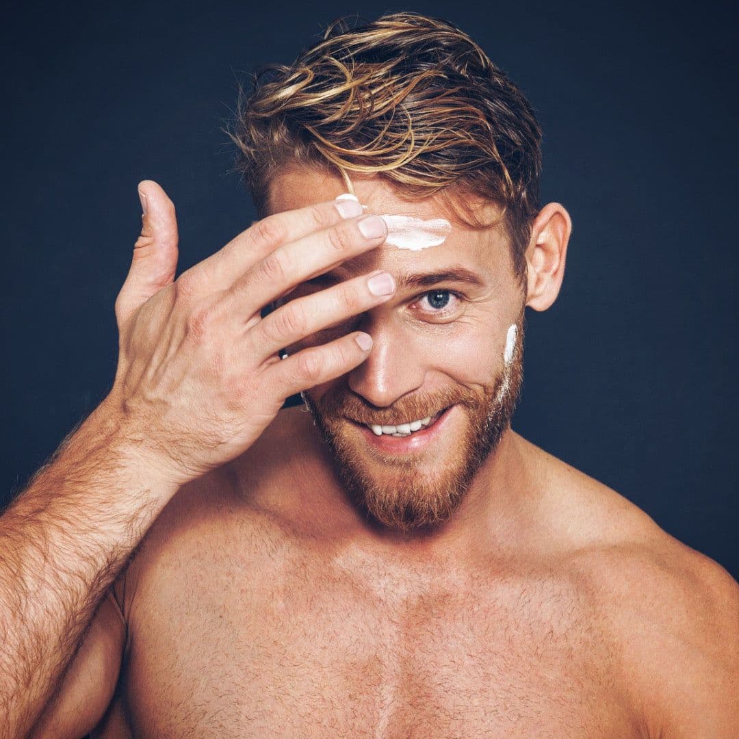 Portrait of a man applying moisturizer